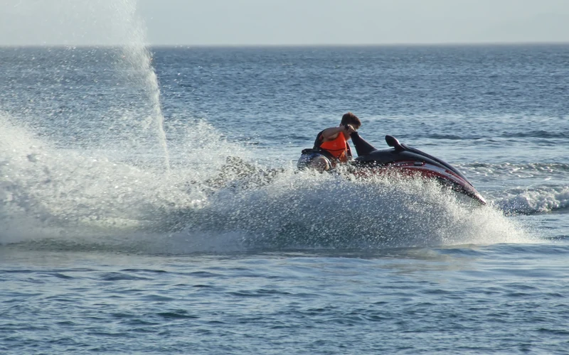 High-speed action sports photography capturing a jet ski carving ocean spray