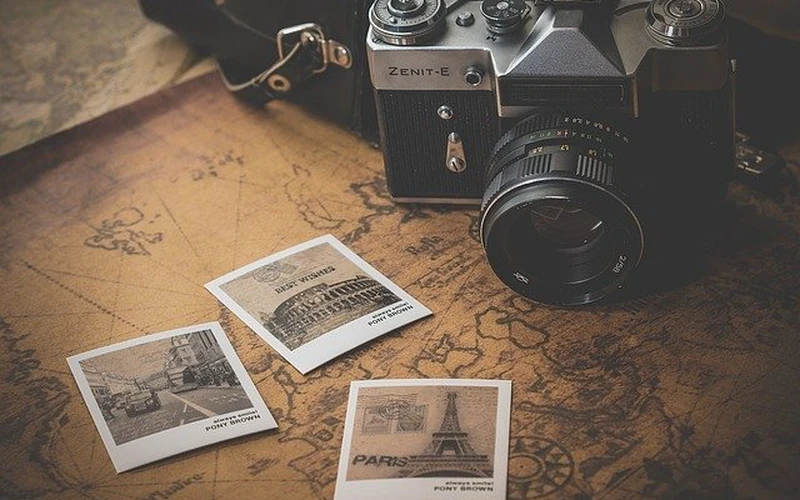 Classic SLR camera and travel photo prints commemorating digital media